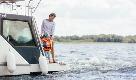 Frau mit Kleinkind auf fahrendem Hausboot, Mirow, Schweriner Seenlandschaft, Foto: TMV/Roth